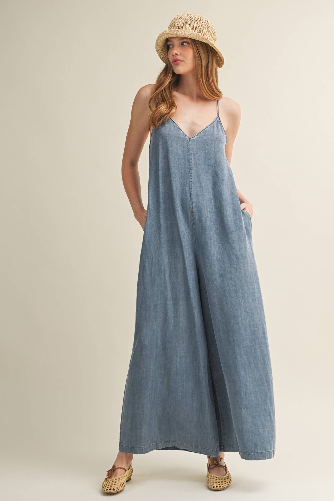 SLEEVELESS DENIM JUMPSUIT WITH CROSS-BACK STRAPS