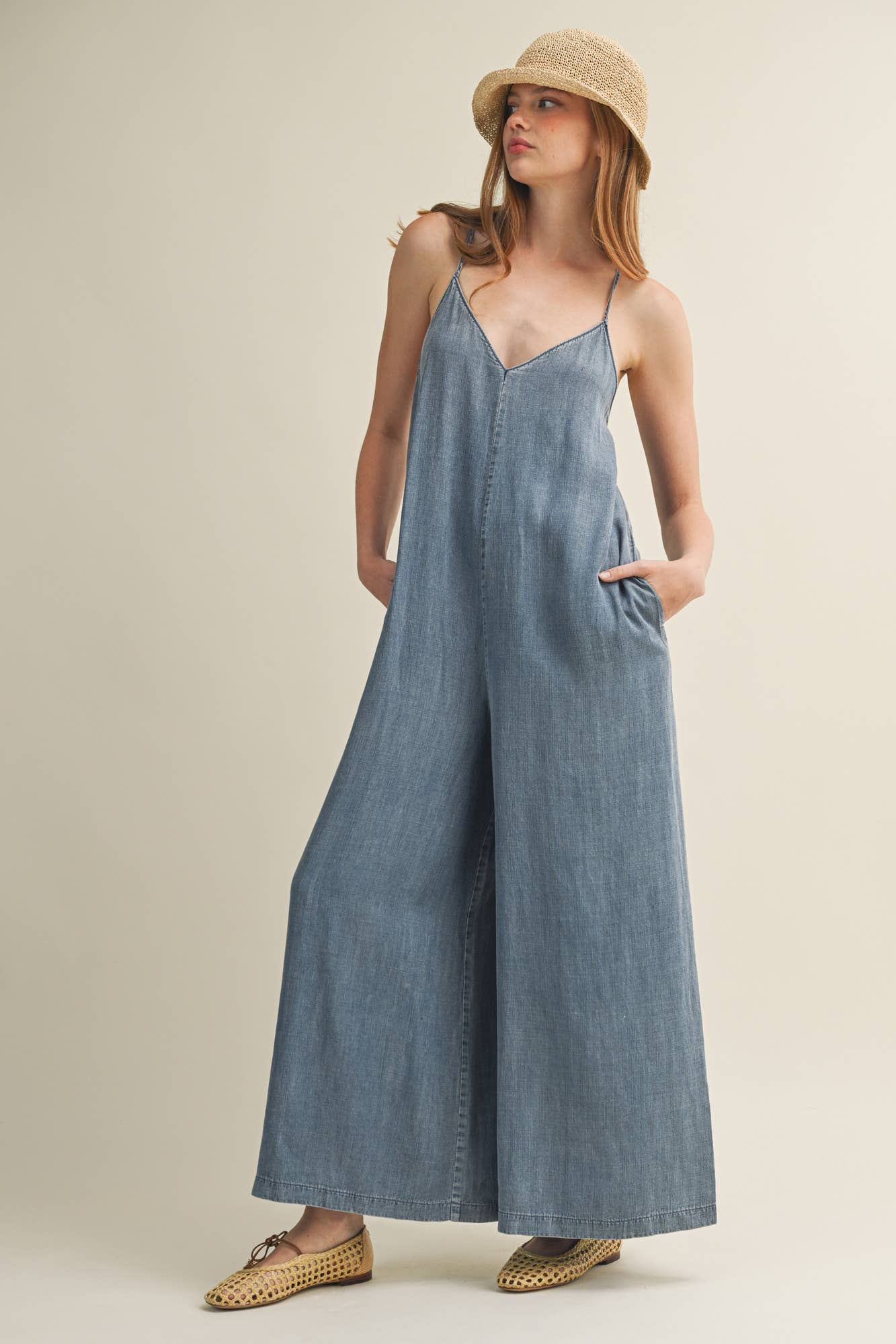 SLEEVELESS DENIM JUMPSUIT WITH CROSS-BACK STRAPS