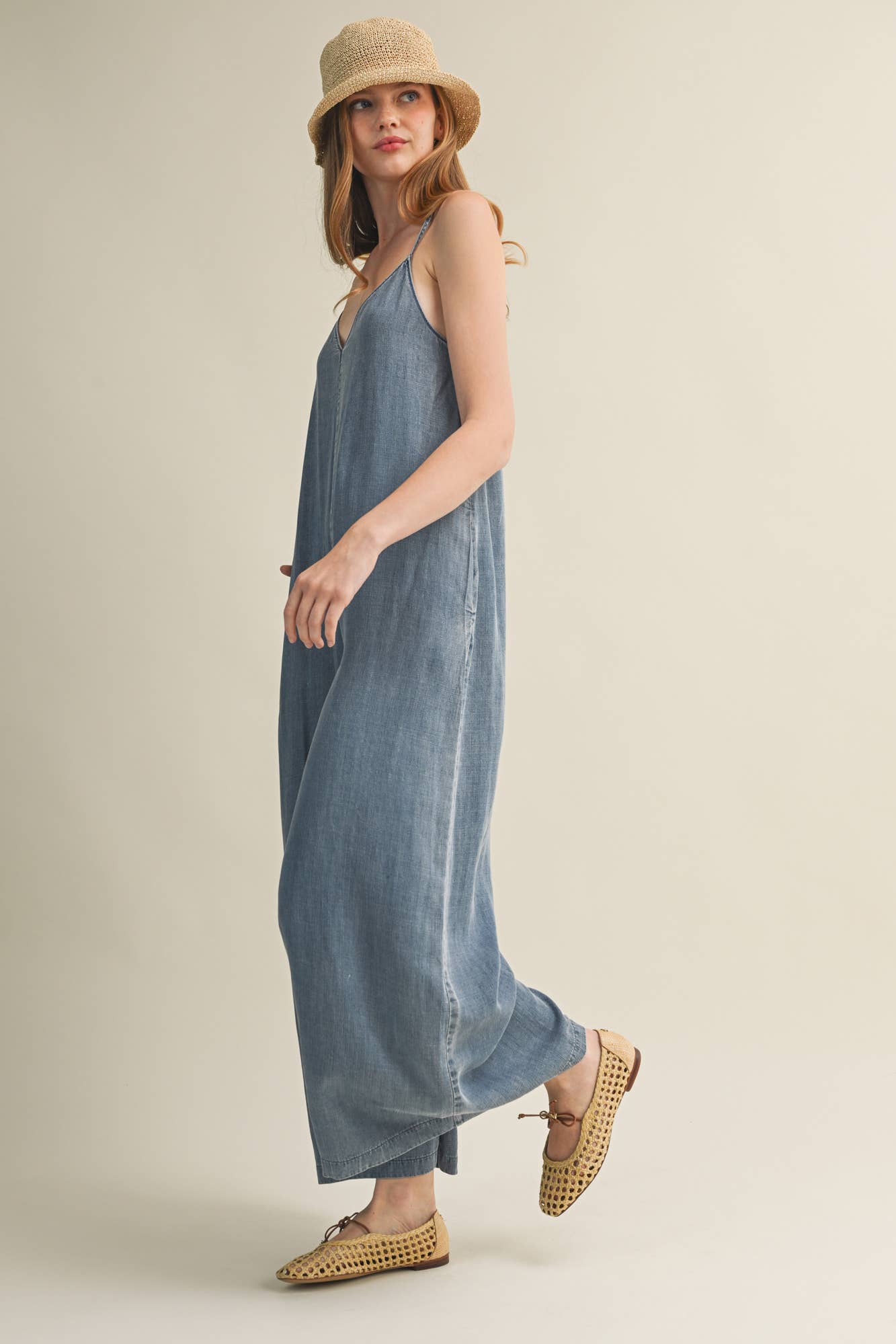 SLEEVELESS DENIM JUMPSUIT WITH CROSS-BACK STRAPS