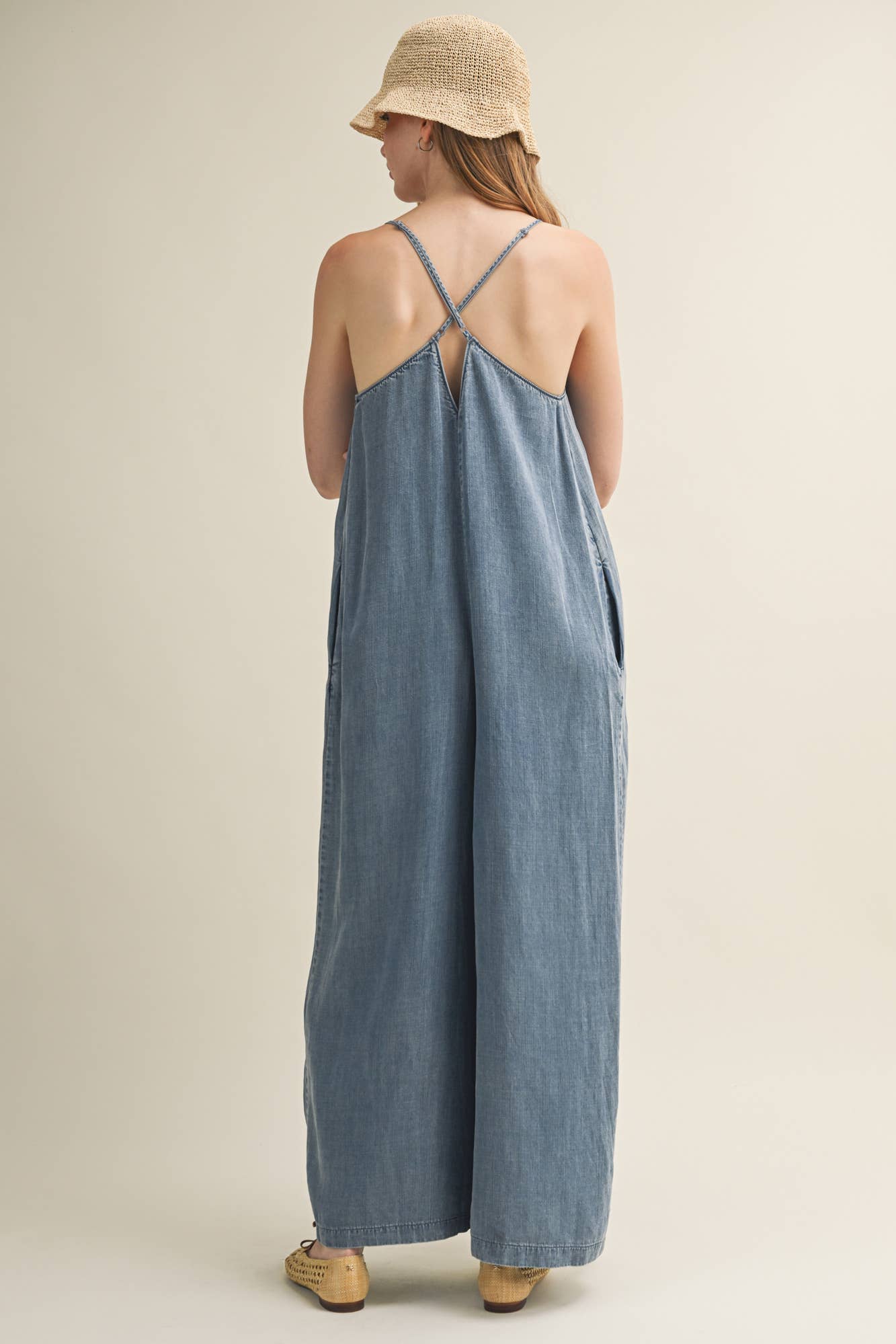 SLEEVELESS DENIM JUMPSUIT WITH CROSS-BACK STRAPS